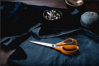 A pair of Fiskars 25cm scissors laying on some blue dressmaking fabric