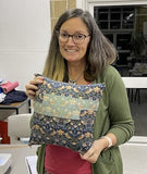 Woman holding a floral fabric bag in an indoor setting