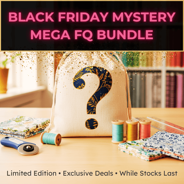 A fabric bag with a large question mark sits on a table surrounded by fabric bundles, spools of thread, and a rotary cutter. Text reads: BLACK FRIDAY MYSTERY MEGA FQ BUNDLE. Limited Edition • Exclusive Deals • While Stocks Last.