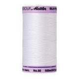 Spool of white thread with purple label on a white background