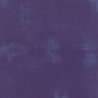 A square of purple quilting fabric with a light purple distressed look as part of the design