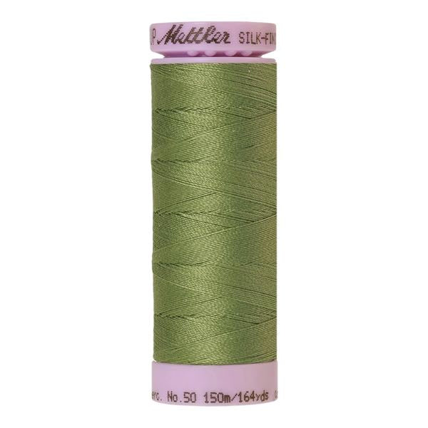 A 150m spool of Mettler silk coated cotton thread in soft green (code 0840), ideal for piecing.