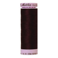 Spool of dark burgundy coloured cotton thread