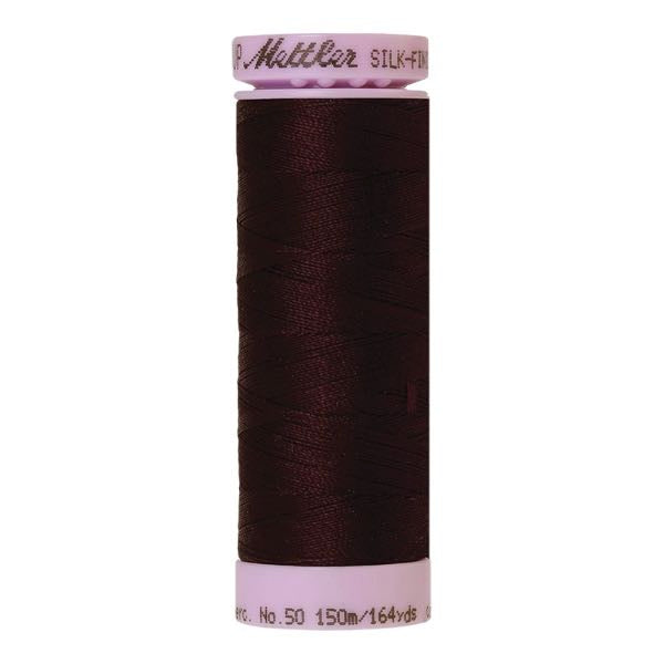Spool of dark burgundy coloured cotton thread
