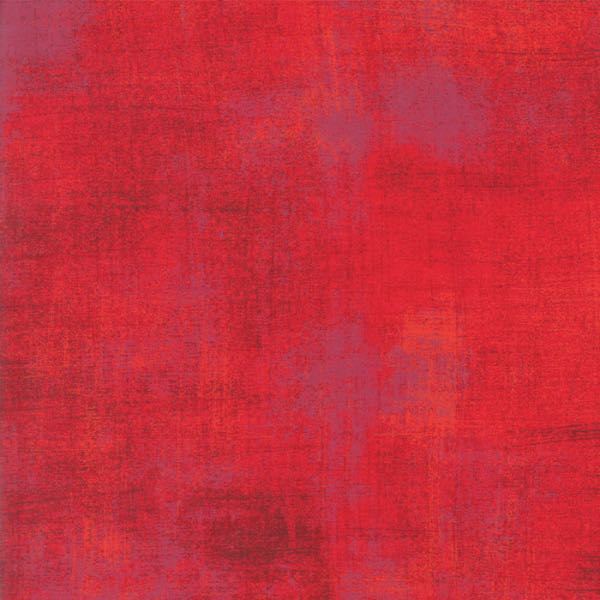 Moda’s Grunge fabric in Rocacco features a textured red background with subtle shade variations and faint purple hints, creating a layered, abstract look.